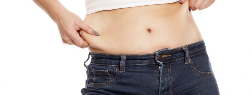 woman pinches her fat on her belly